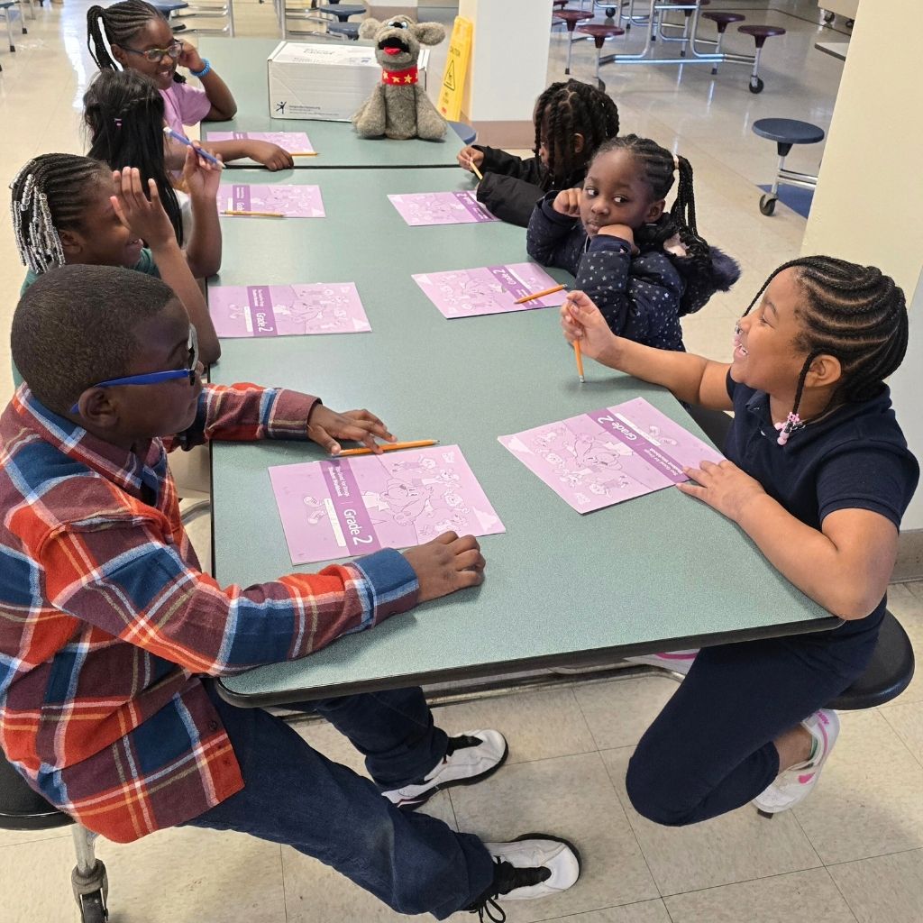 Students collaborate at a table during a free after-school enrichment program in Charlotte, NC with Above and Beyond Students, building academic and social skills.