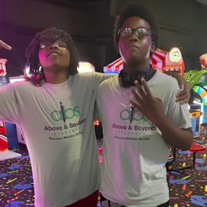 Two students smile together at the arcade during a skating rink field trip with Above and Beyond Students' free summer camp in Charlotte, NC.