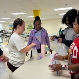 Students shake bags of ice to make homemade ice cream during Above and Beyond Students' free summer camp at Ranson Middle School in Charlotte, NC.