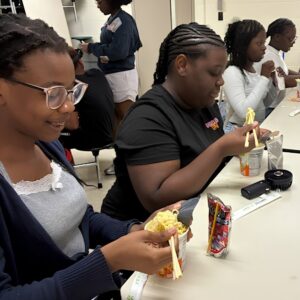 Students practice using chopsticks together during Above and Beyond Students' free summer camp at Ranson Middle School in Charlotte, NC.