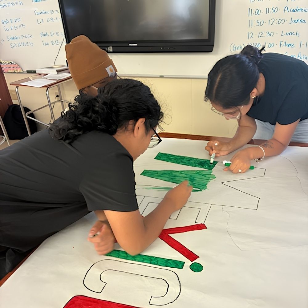 Students paint a Mexico team banner for the ABS Summer Olympics during Above and Beyond Students' free summer camp at Ranson Middle School in Charlotte, NC